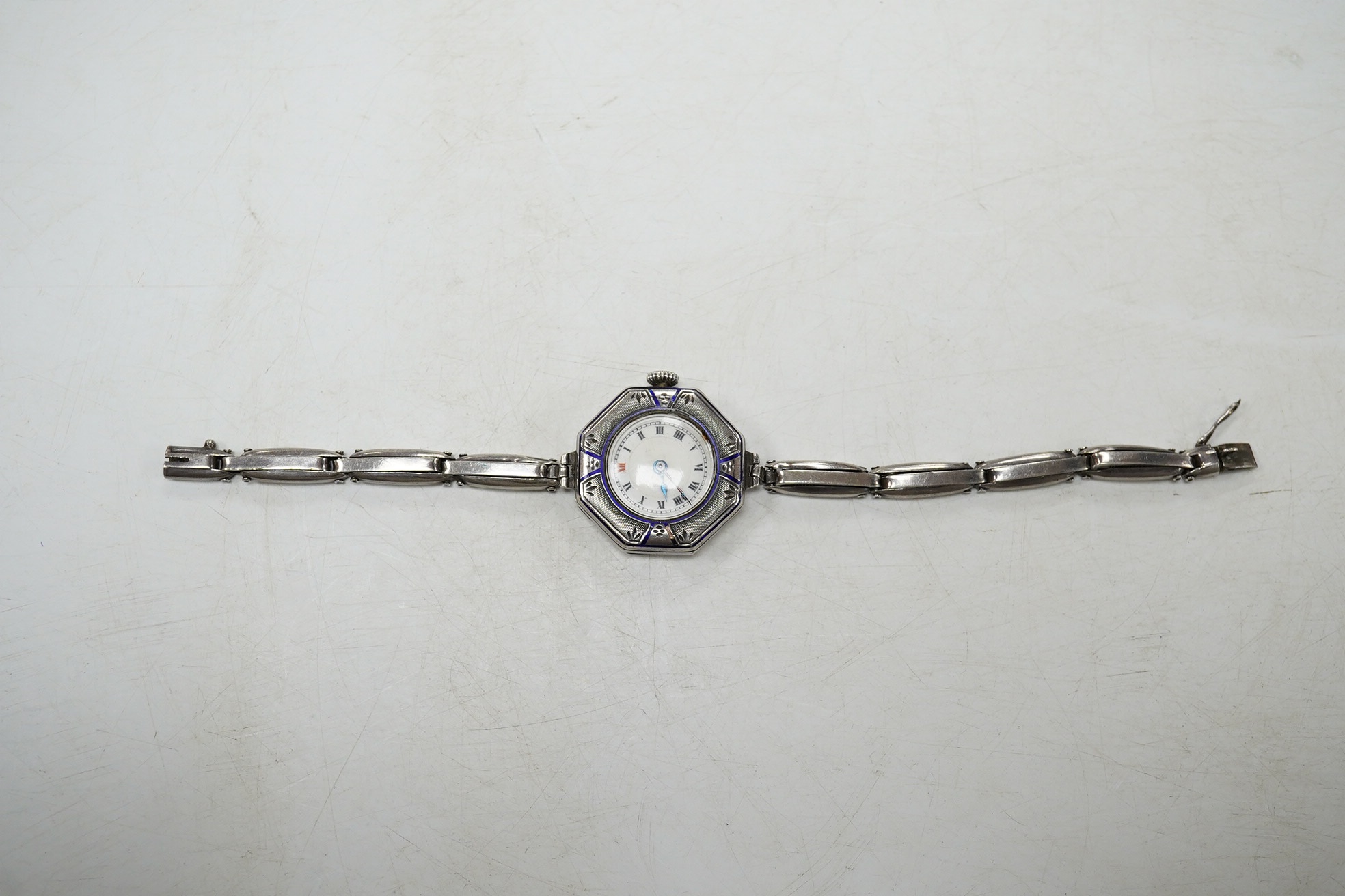 A lady's early 20th century continental sterling and enamel octagonal manual wind wrist watch, on a sterling expanding bracelet, 16.8cm. Condition - poor to fair